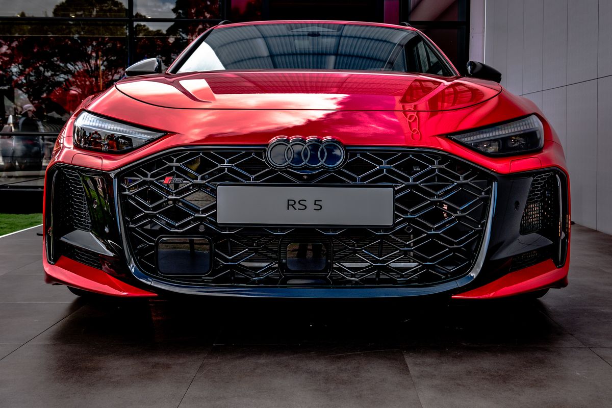 Red Audi RS 5 head-on showing its black honeycomb grille