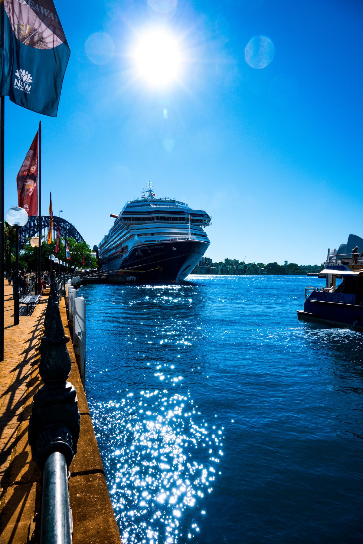 Cruise ship docked at Circular Quay on a bright sunny day, sunlight sparkling on Sydney Harbour