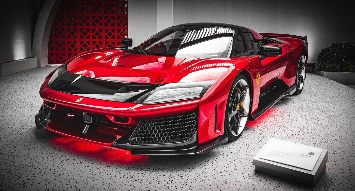 Red and black Ferrari F80 hypercar on display under red floor lighting at the Australian Grand Prix