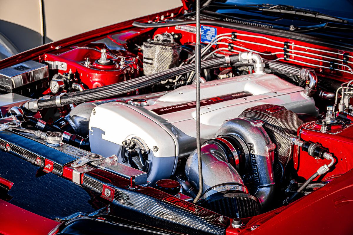 Nissan RB26 engine bay in a red R32 Skyline GT-R with Aeroflow turbo and carbon cooling panel