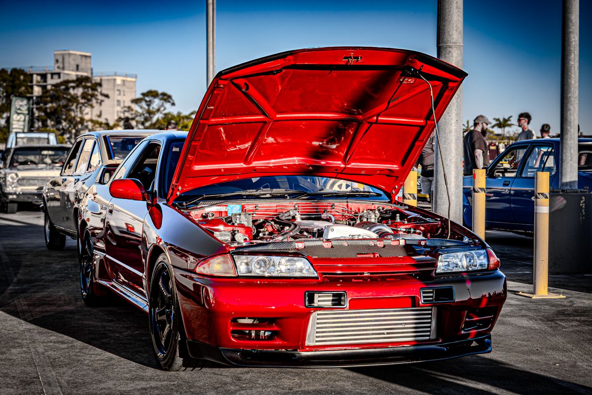 Red Nissan R32 Skyline GT-R with bonnet up at a show and shine car meet