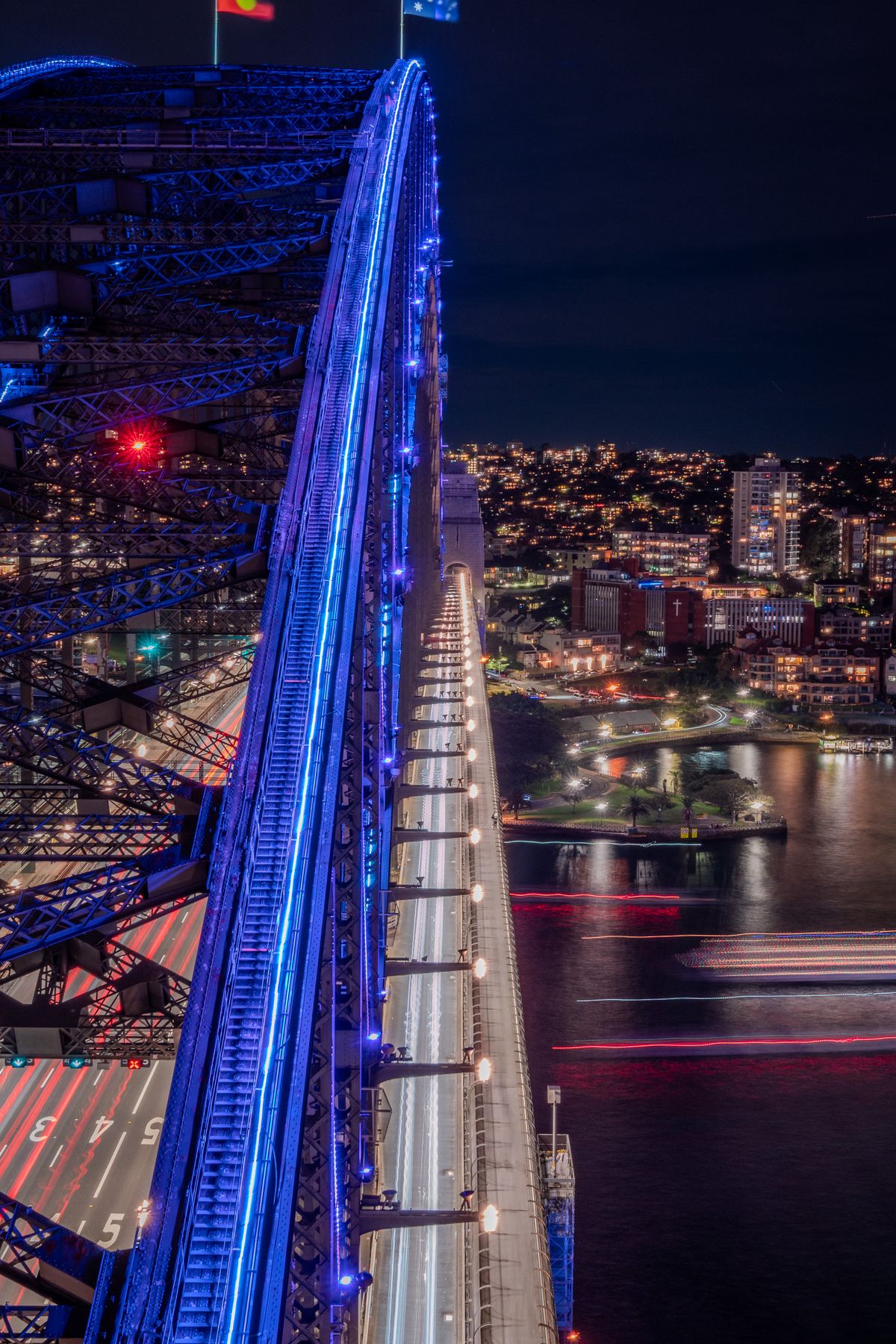 Sydney Harbour Bridge lit blue during Vivid Sydney, looking along the deck at night
